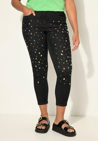 Zwarte denim jeans met meerkleurige rhinestones die over de stof zijn verspreid, ontworpen met een slim fit en vijf zakken.