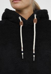 Black fleece hoodie with a textured surface, featuring a drawstring hood and leather accents on the drawstrings.
