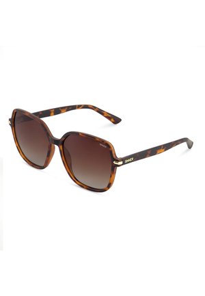 Gafas de sol de carey con lentes cuadradas marrones degradadas y logotipo dorado "SINNER" en las patillas, mostradas en un ligero ángulo sobre un fondo blanco.