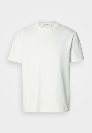 Biała bawełniana koszulka z okrągłym dekoltem. Krótkie rękawy, luźny krój, z subtelnym wytłoczonym logo na przodzie. Gładka tekstura.