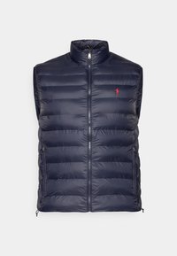 Marinblå quiltad ärmlös väst med frontzipper, ståkrage, dragkedjefickor på sidan och liten röd broderad logotyp på bröstet.