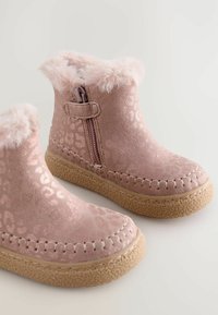 Rosa Leoprint-Ankleboots mit Kunstfellbesatz, Reißverschluss und strukturierten Gummisohlen. Mit dekorativen Nähten entlang der Kante.
