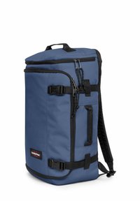 Blauw stoffen rugzak met zwarte accenten. Heeft twee bovenste ritsen, verstelbare schouderbanden en een zijgesp voor een veilige sluiting. Compact ontwerp.