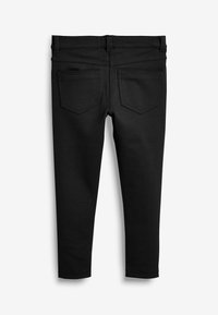 Pantaloni neri elasticizzati con una texture liscia, caratterizzati da un classico design a cinque tasche, cuciture a vista e una silhouette aderente.
