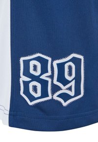 Blåt stof med en hvid lodret detalje, der har broderede tal "89" i mørkeblå med hvid kant, hvilket giver et sporty design.