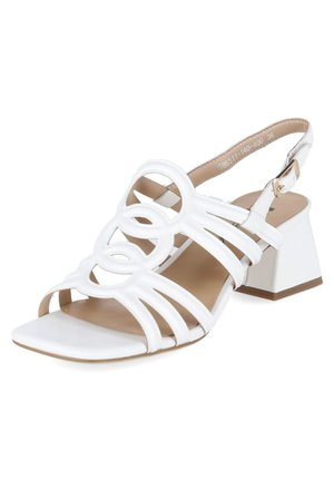 Biała sandałka z odkrytymi palcami, paskami z okrągłymi wycięciami, regulowaną klamrą na kostce i szerokim obcasem.