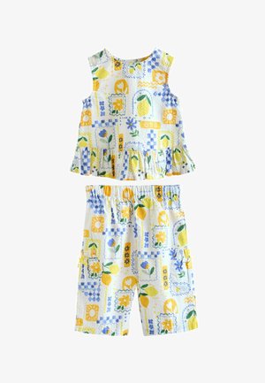 Ujjatlan felső és térdig érő rövidnadrág készlet sárga citromokkal, kék virágokkal és geometriai mintákkal fehér, texturált szöveten.