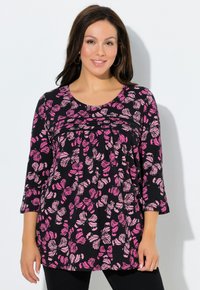 Schwarzes Oberteil mit einem floralen Muster aus pinken Schmetterlingen, rundem Halsausschnitt und dreiviertellangen Ärmeln. Mit Raffungen unterhalb der Brust.