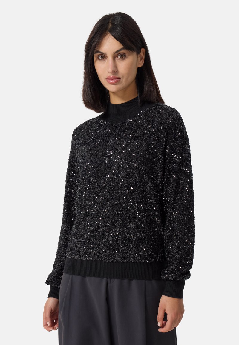 Maglione nero con paillettes, dotato di scollatura a coste e polsini. La parte superiore presenta una superficie testurizzata e riflettente, con un design a vestibilità rilassata.