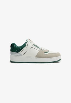 Zapatillas con una combinación de colores blanco y verde, que cuentan con materiales de cuero y gamuza, un collar almohadillado y detalles perforados en los lados.