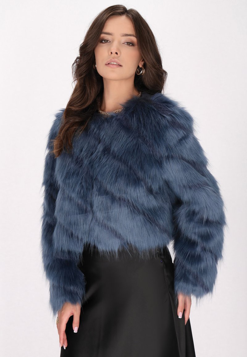 Giacca cropped in pelliccia sintetica blu navy con una texture morbida, caratterizzata da un collo tondo e maniche lunghe, abbinata a una gonna in satin nera.