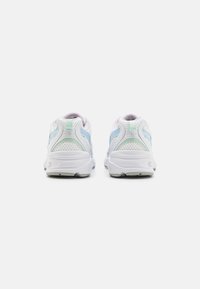 Un paio di scarpe atletiche bianche con accenti blu chiaro e verde menta, viste da dietro su uno sfondo bianco puro.