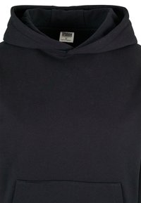 Sweat à capuche noir avec poche avant et étiquette intérieure visible indiquant la marque et la taille XS.