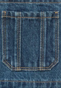 Denim tkanina zadnji žep s vidno šivano v svetlo rjavi barvi. Žep ima pravokotno obliko, ki vključuje podkotno rez na dnu.