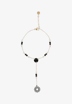 Brățară cu lanț auriu, mărgele negre, element central circular negru și charm floral negru agățat. Închizătoare ajustabilă și lanț de extensie.