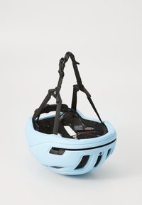 Svetlomodrá cyklistická prilba s čiernymi nastaviteľnými popruhmi, ventilačnými otvormi a polstrovaným interiérom. Má kompaktný, aerodynamický dizajn.
