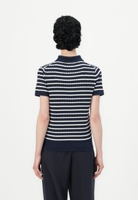 Tamsiai mėlynas ir baltas dryžuotas trumpomis rankovėmis polo marškinėliai su įrėminta tekstūra ir apykakle, matomi iš nugaros.