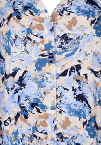 Barevná květinová blůza s kombinací modrých, béžových a navy vzorů, s knoflíkovým zapínáním a měkkou texturou látky.