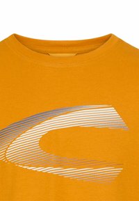 Kortærmet T-shirt med rund hals i lys gul-orange, prydet med et sølv- og hvidt grafisk design med linære detaljer. Blød stofstruktur.