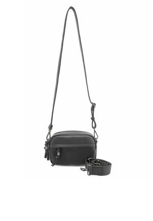Borsa a tracolla in pelle nera con una texture liscia, forma arrotondata, tracolla regolabile e chiusura con zip ornata da frange decorative.