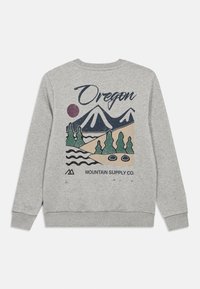 Sweatshirt gris présentant un design graphique avec des montagnes, des arbres et de l'eau, étiqueté "Oregon", avec un soleil violet rond et des couleurs contrastées.