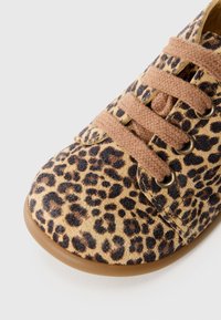 Buty z płótnem w panterkę z brązowymi sznurowadłami, okrągłym noskiem i gumową podeszwą. Charakteryzują się metalowymi oczkami oraz miękką fakturą.