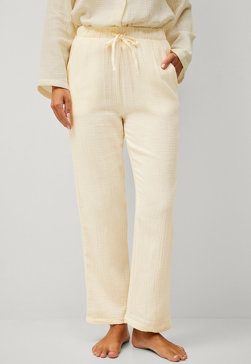 Licht beige, structuurpijama broek met een elastische tailleband en trekkoord, voorzien van zijzakken en een ontspannen pasvorm.