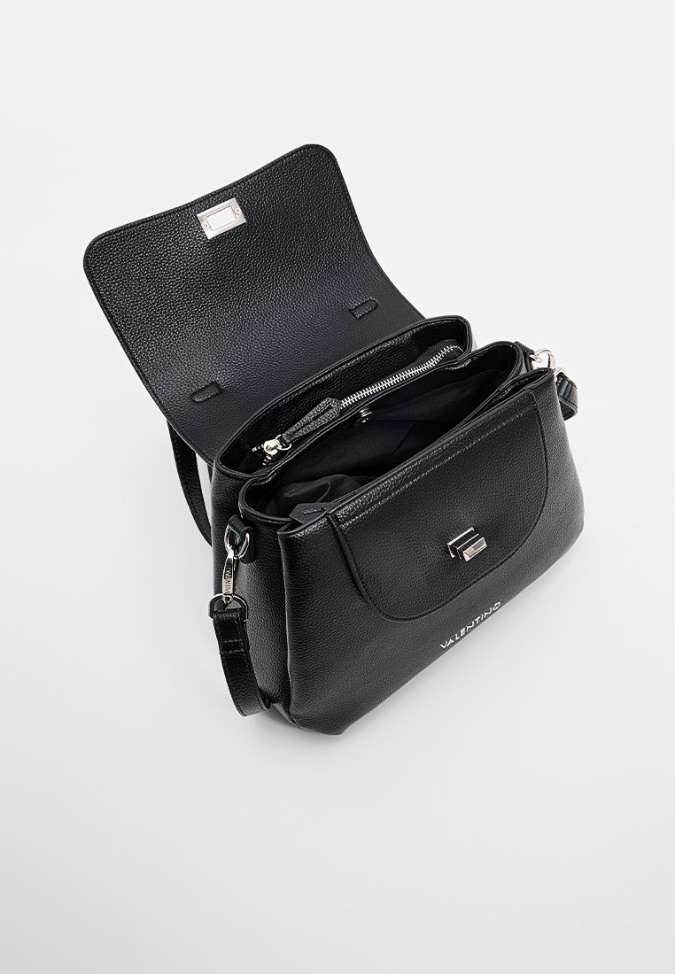 Sac à main en cuir noir avec une finition texturée, une fermeture à rabat, des accessoires en argent et plusieurs compartiments à l'intérieur. Bandoulière réglable incluse.
