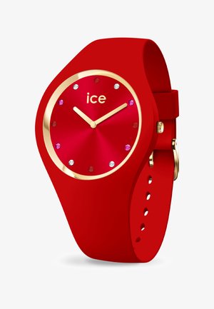 Orologio in silicone rosso con cassa tonda, accentuazioni dorate e indicatori delle ore in gemme multicolori. Presenta una texture liscia e un cinturino regolabile.