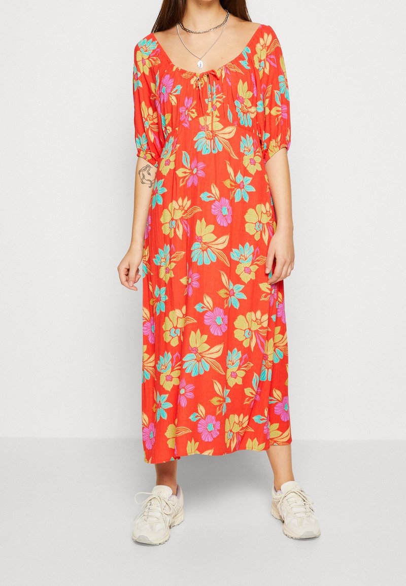 Rotes Maxikleid mit puffigen Ärmeln, das mit blauen, rosa und gelben Blumen verziert ist; leichtes Gewebe; gerafftes Dekolleté.