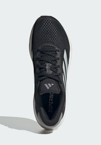 Black athletic shoe with a mesh upper and textured finish, featuring gray stripes, round toe, lace-up design, and cushioned sole.
