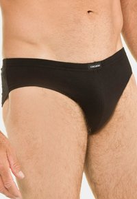 Musta puuvillainen miesten alushousut, joissa on matala malli, pehmeällä joustavalla vyötärönauhalla ja vähäisillä sauman yksityiskohdilla mukavuutta varten.