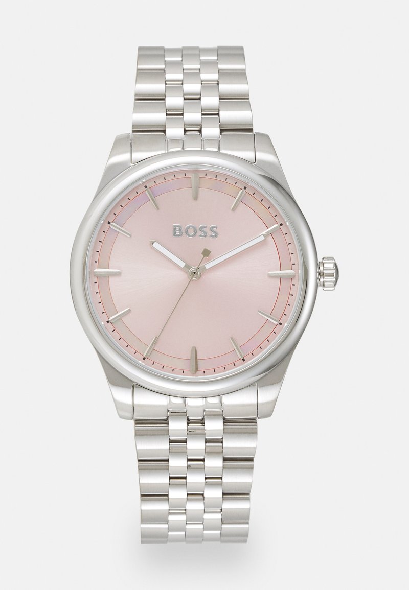 Relógio de aço inoxidável prateado com caixa redonda, mostrador em gradiente rosa, marcadores de horas prateados e bracelete em corrente. Logotipo às 12 horas.