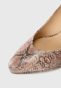 Pointed-toe high heel in pink and brown snake print texture with a smooth inner lining and cutout sides. Subtle shine on the surface.