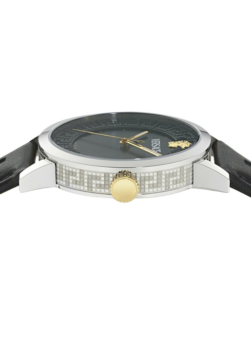 Runde silberne Uhr mit schwarzem Zifferblatt, goldenen Zeigern und Krone, schwarzem Lederarmband und goldenem Medusa-Emblem nahe der 12 Uhr-Position.