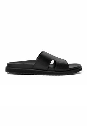 Sandales noires à glissière avec une tige en cuir lisse, design à bout ouvert avec des accents découpés et une semelle en caoutchouc texturé.