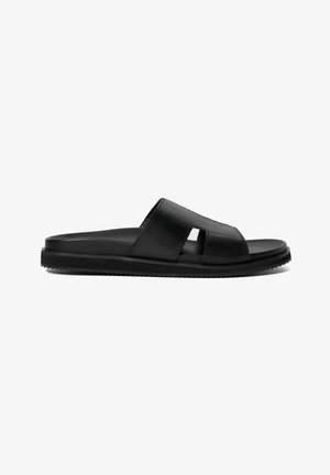 Black slide sandals featuring a smooth leather upper, open toe design with cut-out accents, and a textured rubber sole.