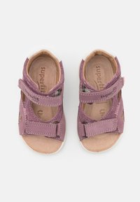 Lilla lær sandaler med to justerbare Velcro-remmer, åpne sider og en beige lær innersåle. Hvite gummisåler for godt grep.
