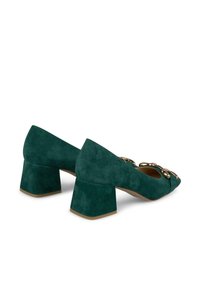 Scarpe in camoscio turchese con tacco a blocco e punta affusolata, presentano un dettaglio di catena sul frontale. Il tacco è alto circa 5 cm e ha una finitura testurizzata.