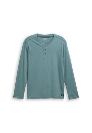 Camisa henley de manga larga en verde agua, hecha de tela suave, con cuello redondo, tapeta de tres botones y detalle del logo en el dobladillo.