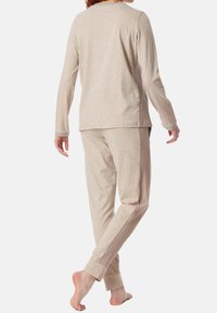 Beige long-sleeve top and matching pants made of soft fabric, featuring ribbed accents along the sides and cuffs.