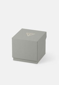 Siva teksturirana četvrtasta kutija s trokutastim Guess logotipom na vrhu, postavljena na jednostavnoj bijeloj pozadini.