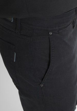 Crne traperice od denima s ravnim krojem, suptilnom teksturom, prednjim i stražnjim džepovima, te malom plavom oznakom blizu bočnog šava.