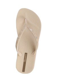 Infradito beige con suola texture e cinturini decorati. Nome del marchio "Ipanema" su un'etichetta marrone. Design leggero e minimalista.
