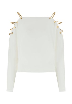 Haut blanc à manches longues avec des détails en chaîne dorée et boutons le long des épaules et des bras supérieurs, présentant un col carré.