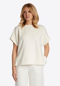 Licht beige short-sleeve top van zachte stof met een ronde halslijn en een losse pasvorm. Voorzien van zijzakken en een rechte zoom.