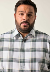 Camisa de cuadros de manga corta con rayas verdes, blancas y beige. Cuello abotonado y botones en la parte frontal. Material de algodón con una textura suave.