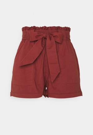 Shorts de algodón rojos con cintura fruncida, cinturón de tela anudado y dos bolsillos frontales. Presentan un dobladillo vuelto y una textura suave.