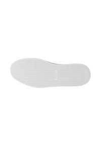 Semelle blanche de chaussure de sport vue par le dessous, avec un motif hexagonal et une étiquette de marque rectangulaire au centre.