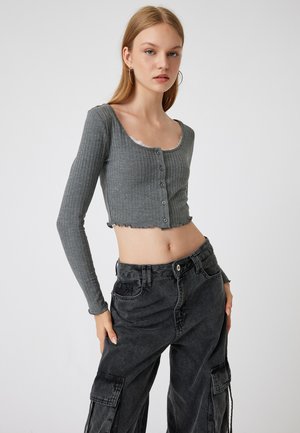 Szary prążkowany długi rękaw crop top z dekoltem w serek i koronkowym wykończeniem, z guzikiem i surowym wykończeniem dołu, w zestawie z czarnymi spodniami cargo.